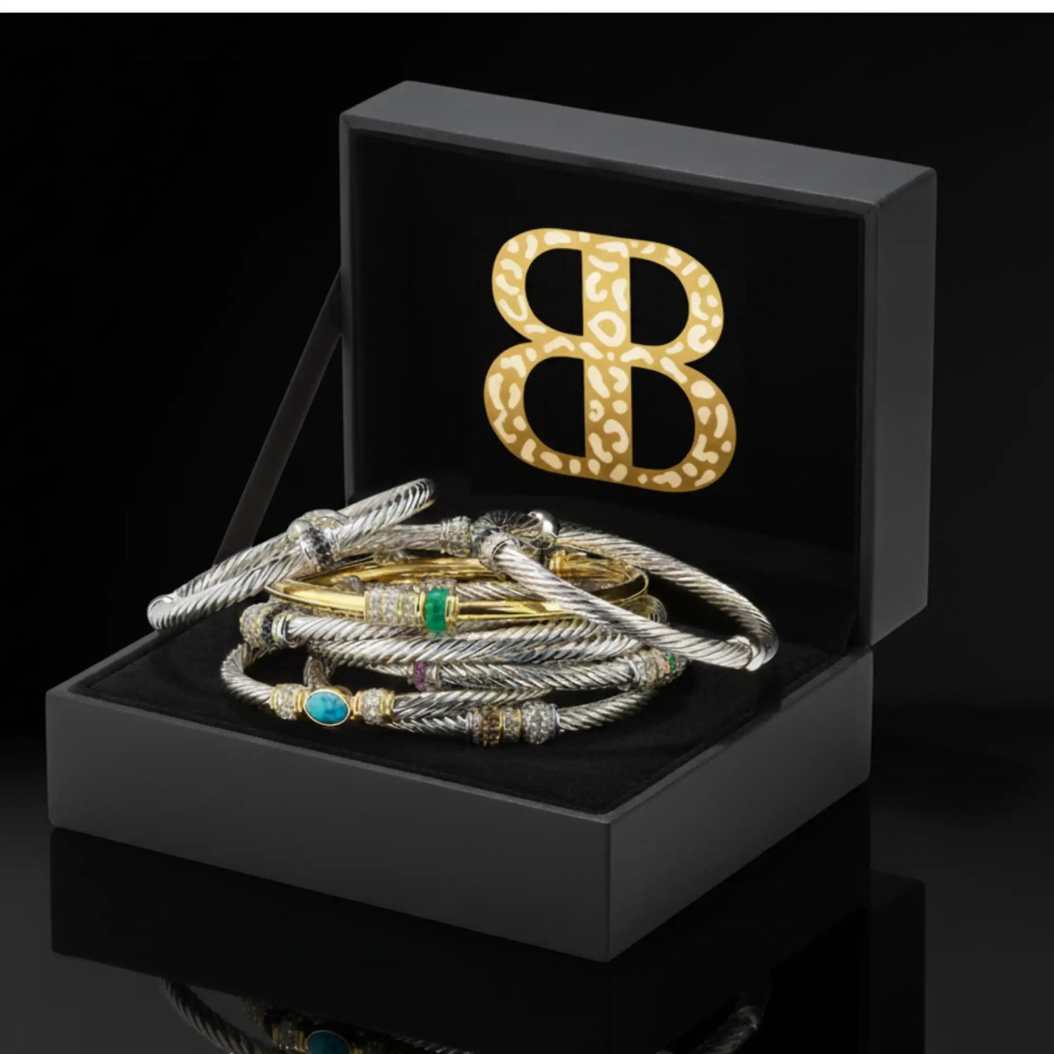 A collection of david yurman cable bracelets in silver and gold tones, adorned with turquoise, emerald, and diamond accents.