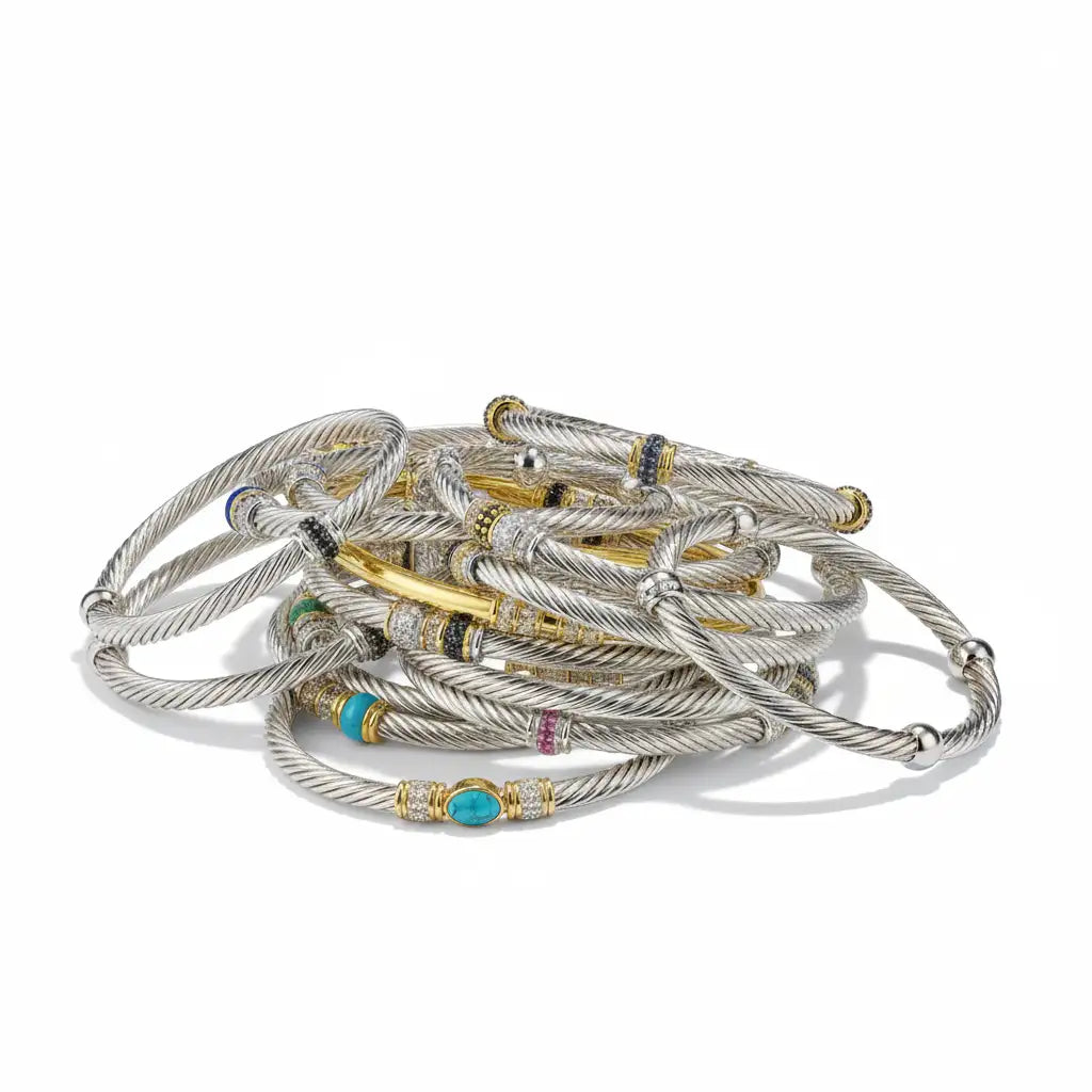 A collection of david yurman cable bracelets in silver and gold tones, featuring turquoise stones, diamonds, and black onyx accents.