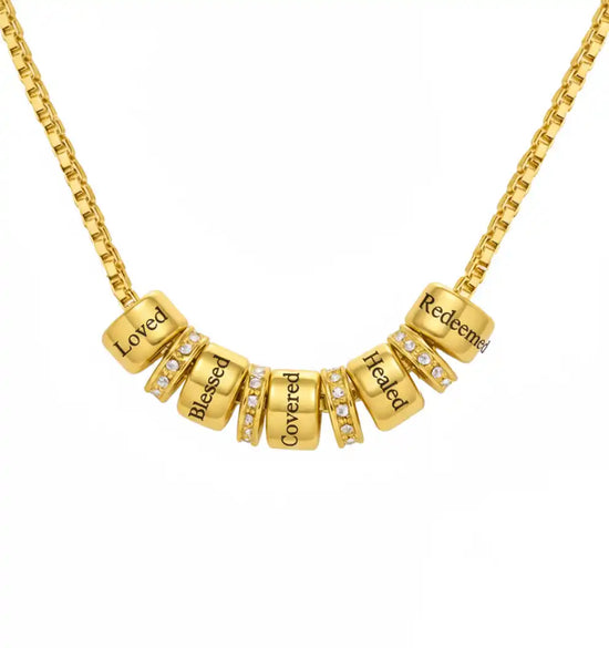 Gold chain necklace with five inscribed barrel beads and four pavé-set crystal spacer beads.