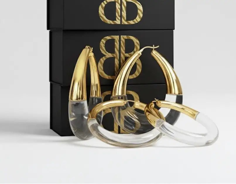 Gold and clear acrylic hoop earrings with a sleek, modern design.