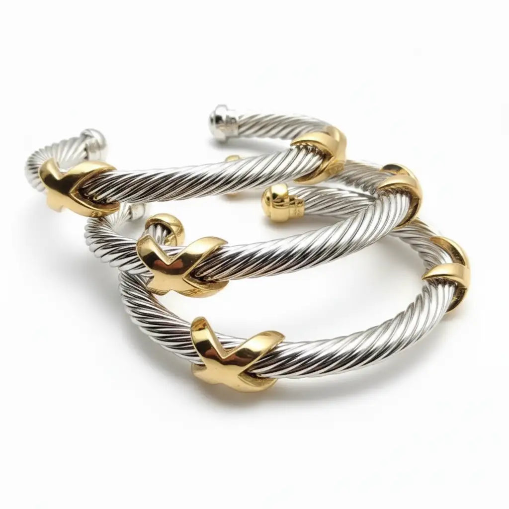 Silver and gold-tone twisted cable bracelet with distinctive x-shaped clasps.