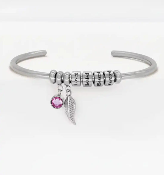 Silver open cuff bracelet with pink gem and feather charms