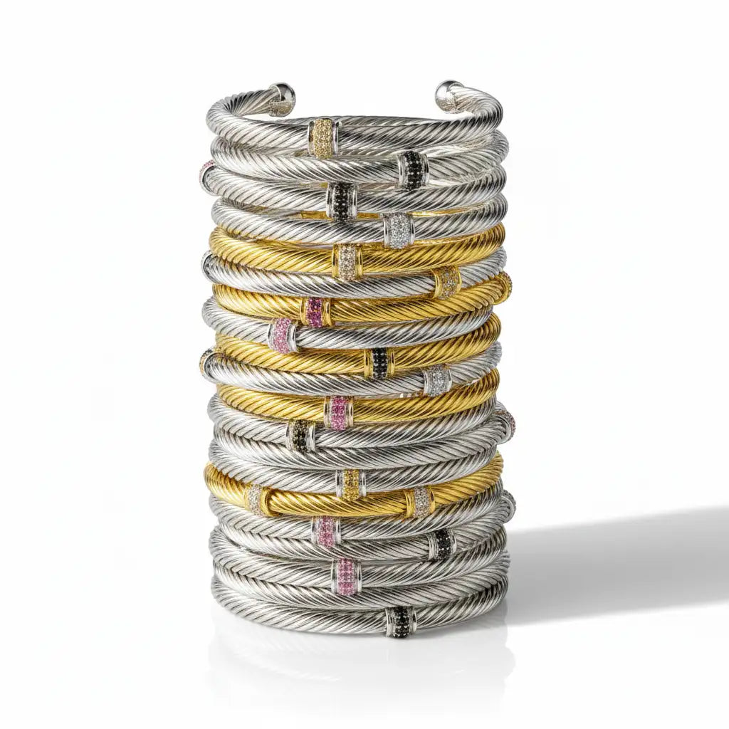 Stack of david yurman cable bracelets in silver and gold with gemstone accents.