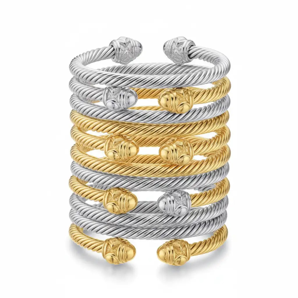 Stacked cable bracelets in silver and gold tones, each featuring twisted rope design with ornate spherical ends.